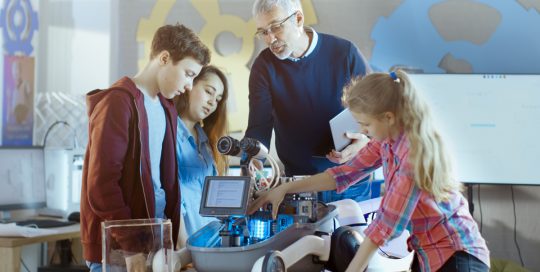 Teacher with students working on machine
